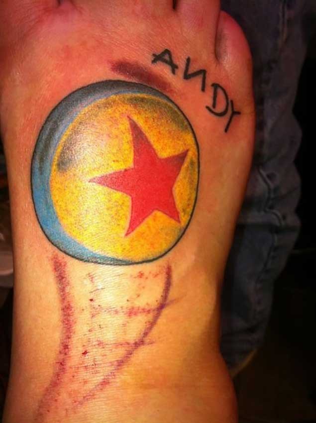 Tiny colored little ball tattoo on foot stylized with star and lettering
