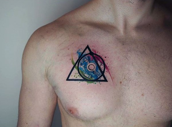Winziges im geometrischen Stil farbiges Tattoo an der Brust