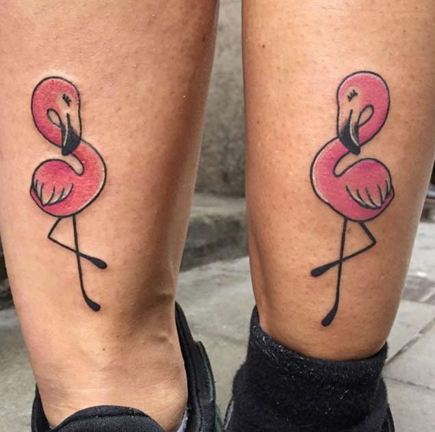Tiny identical pink flamingos tattoo on legs