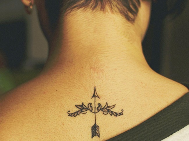 Tiny little black ink upper back arrow tattoo