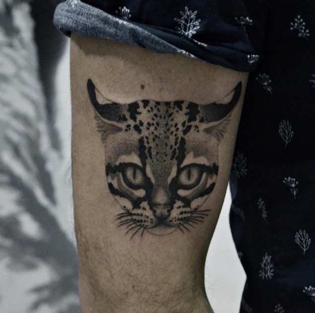 Tiny natural looking black ink wild cat face tattoo on arm