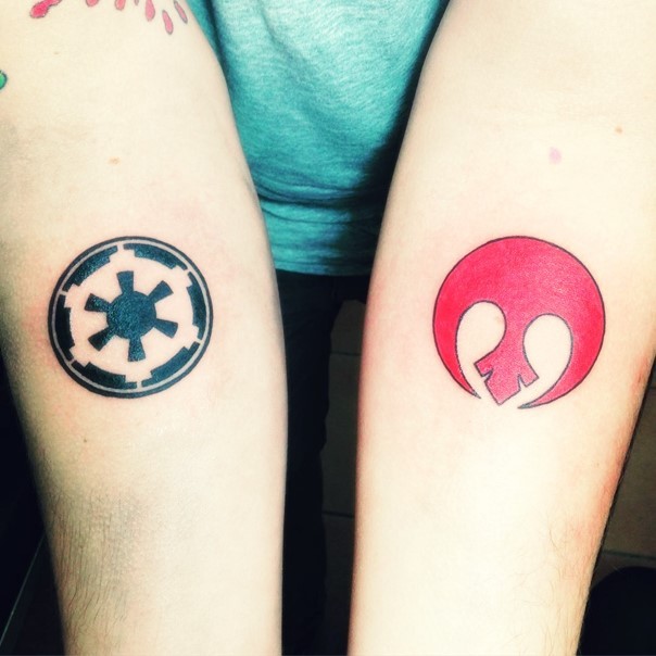 Tiny nice painted various colored Empire and Rebel emblems tattoo on forearms