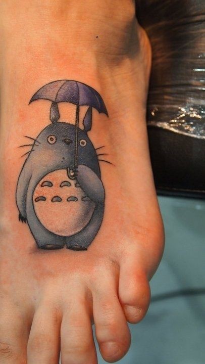 Winzige alte cartoonische farbige lustige Kreatur mit Regenschirm Tattoo am Fuß
