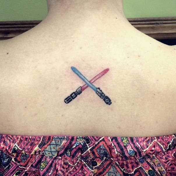 Tiny old cartoon style colored back tattoo of crossed lightsabers