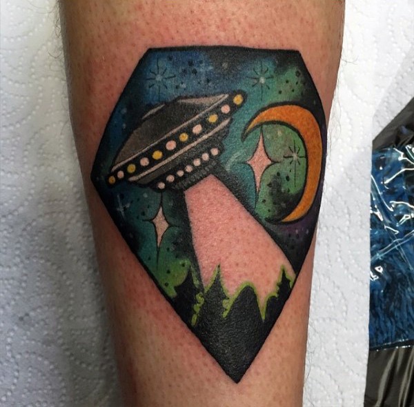Tiny simple painted and colored alien ship in night sky tattoo on leg
