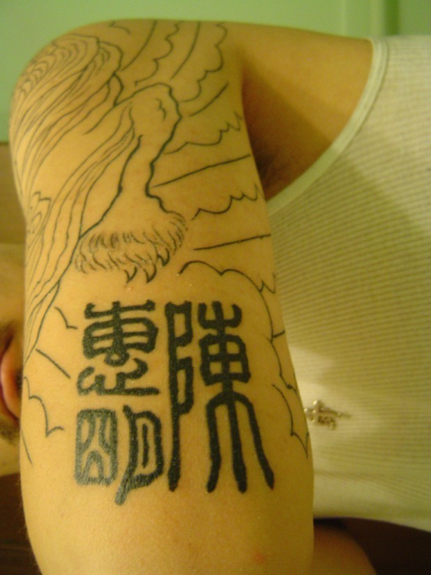 Tatuaje en el brazo, diseño chino con jeroglíficos