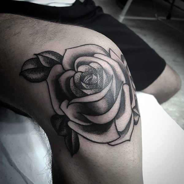 Traditional old school style rose flower with leaves black and white tattoo on knee with dotted work elements