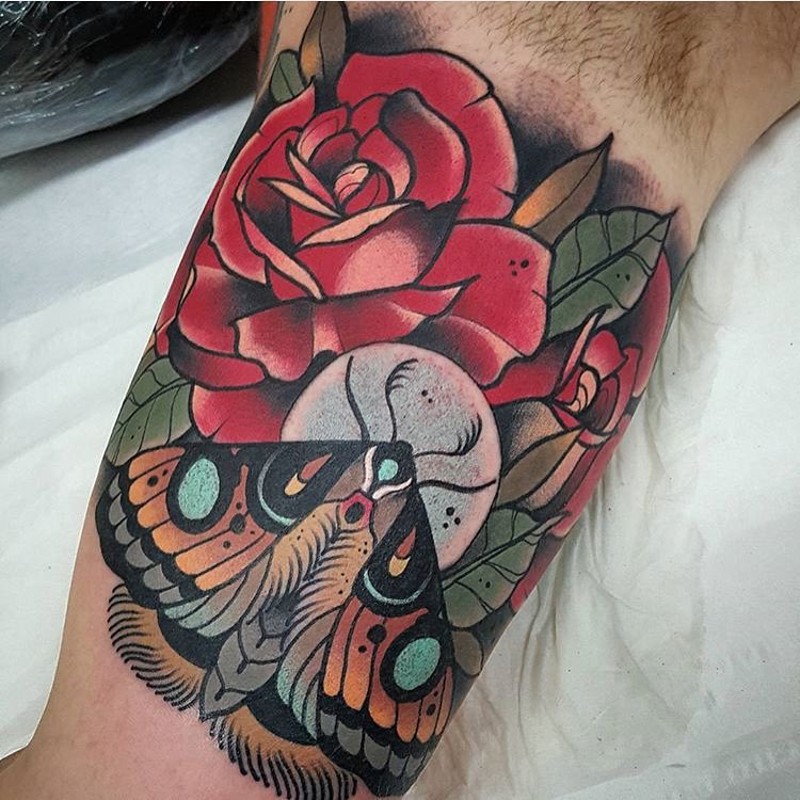 Traditional red roses and moth  colored biceps tattoo in old school style