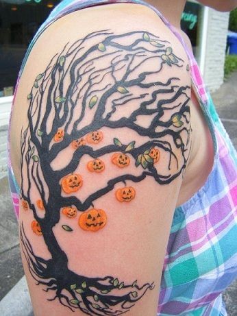 Tatuaje en el brazo,
árbol negro con decorado con calabazas de Halloween