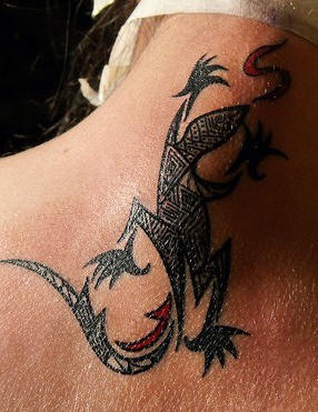 El tatuaje tribal de una lagartija en color negro y rojo hecho en el cuello