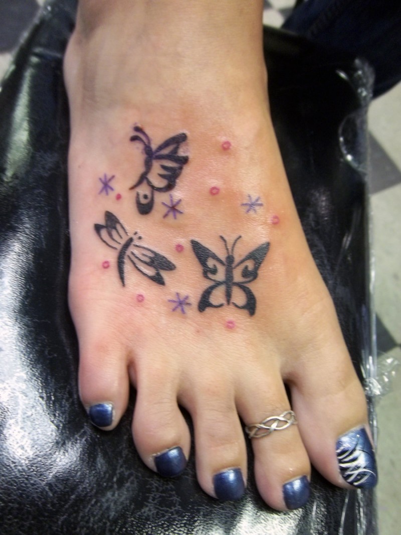 farfalla tribale con fiocchi di neve tatuaggio su piede