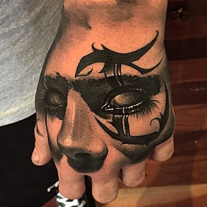 Tribal style 3D small black and white hand tattoo of woman face with symbol