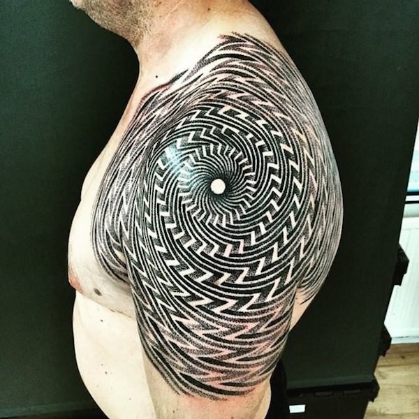 Tribal style big black and white hypnotic tattoo on shoulder area