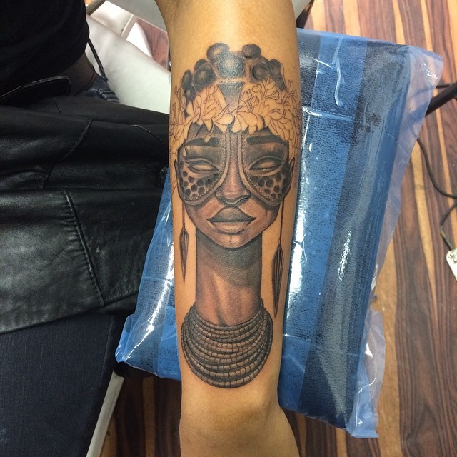 Tribal style colored forearm tattoo of tribal woman with jewelry