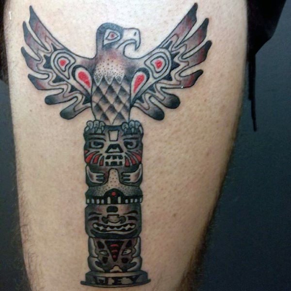 Tribal style colored mystic statue tattoo on thigh