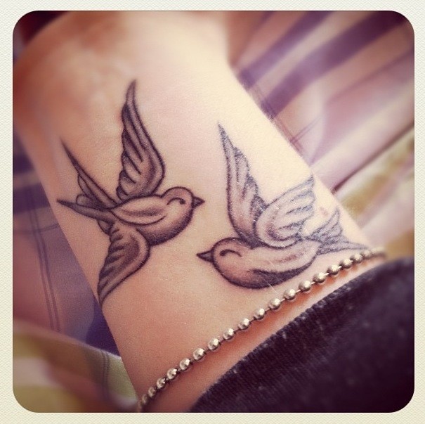 Tatuaje en la mano,  dos aves pequeñas simples