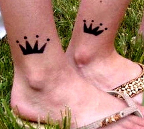 Two black crown tattoo on the feet