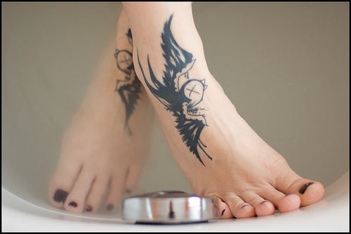 Two black swallows flying foot tattoo