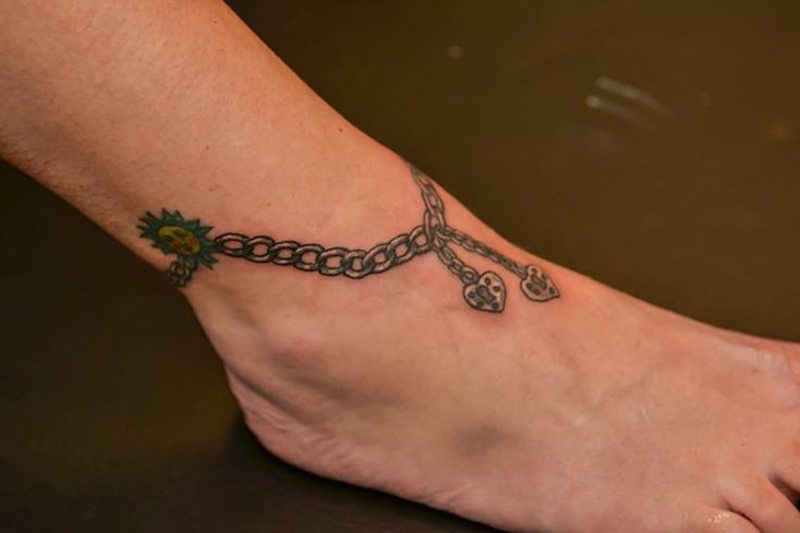 Tatuaje de cadena con dos corazones  en el tobillo