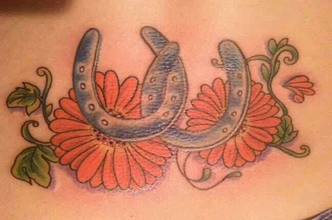 Two horseshoes and orange flowers tattoo
