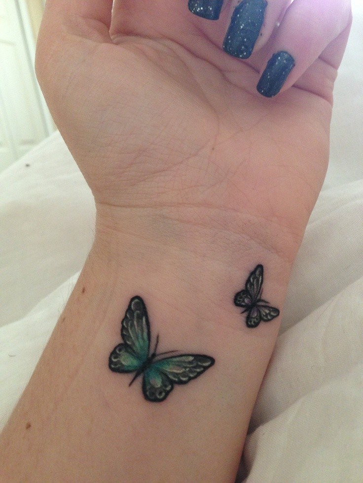 Two small butterfly tattoos on girls wrist