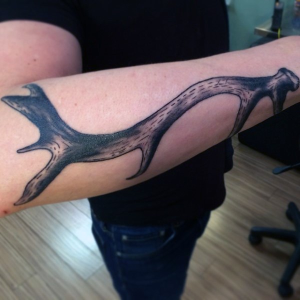 Typical black and gray style forearm tattoo of deers horn