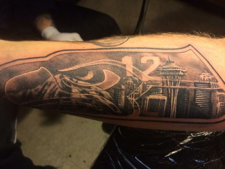 Typical black ink forearm tattoo of city sights and number