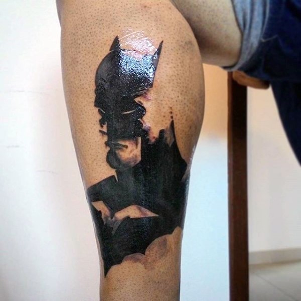 Typical black ink leg tattoo of Batman face