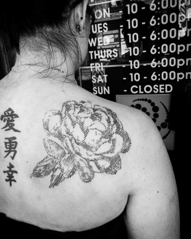 Typical black ink linework style scapular tattoo of big rose