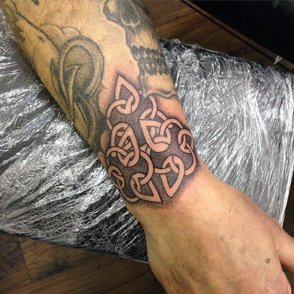 Typical black ink wrist tattoo of small knot