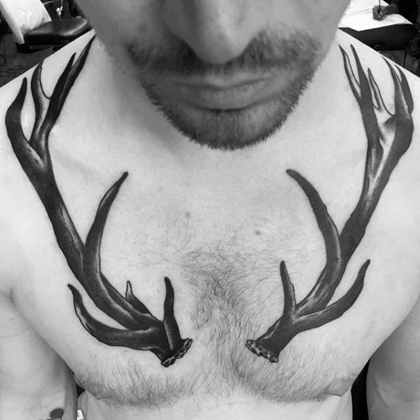 Typical blackwork style big deer horns tattoo on chest