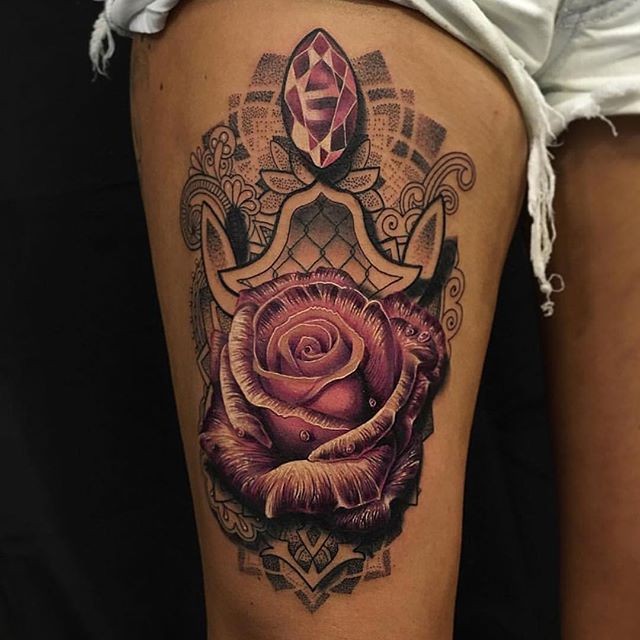 Charakteristisch farbiger Oberschenkel Tattoo der großen Rose stilisiert mit Indischen Blumen