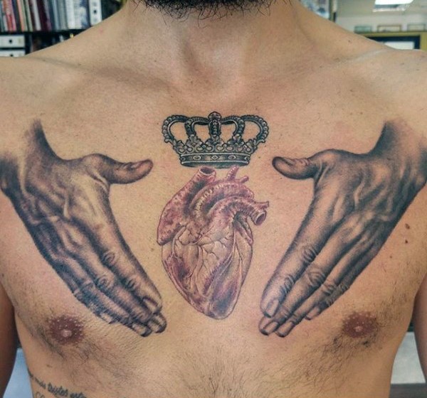 Typical colored chest tattoo of human hands with heart and crown