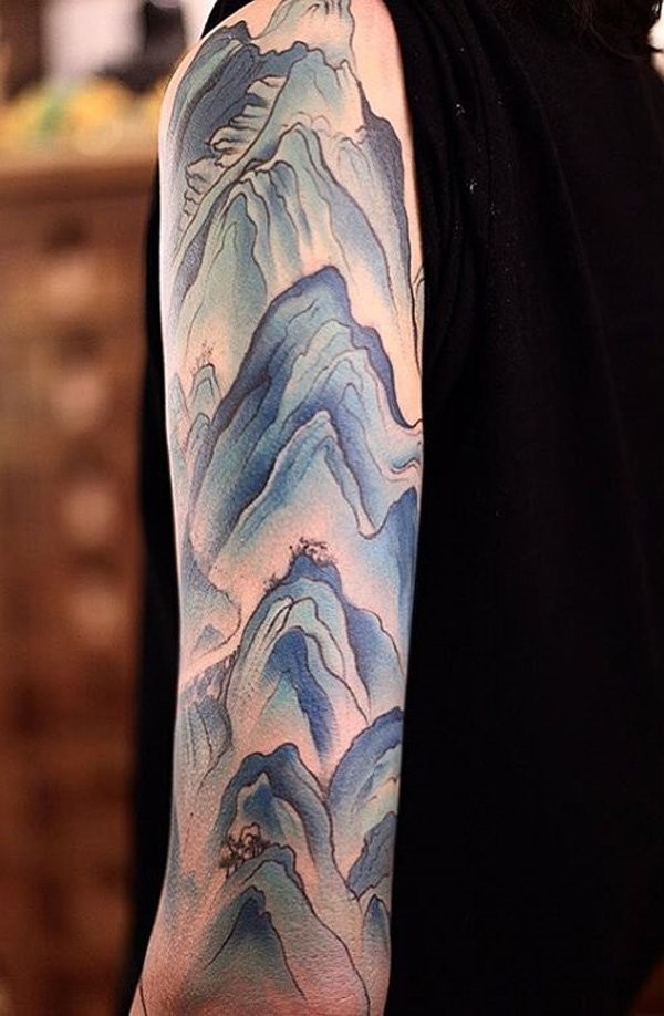 Typical colored sleeve tattoo of mountains