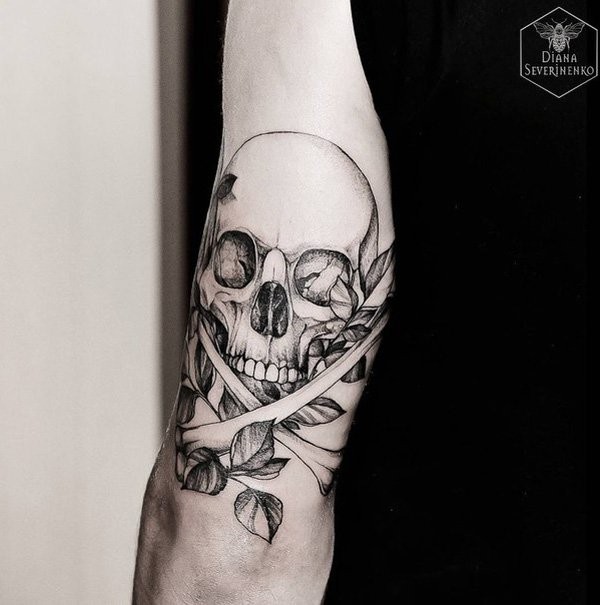 Typical engraving style black ink human skull with leaves