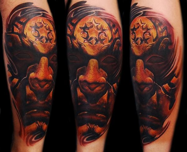 Typical illustrative style colored arm tattoo of demonic face with star shaped symbol