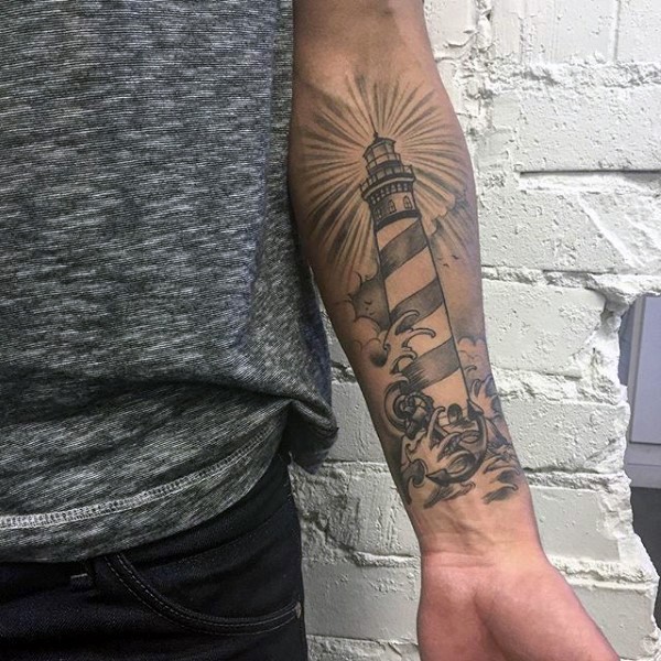 Typical new school style black and white lighthouse with waves tattoo on forearm