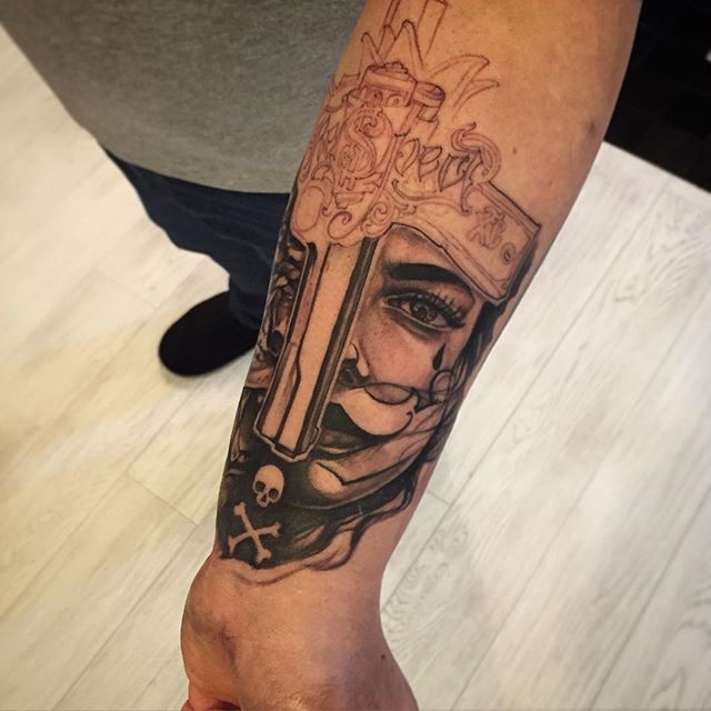 Unfinished black ink forearm tattoo of mans face with pistol