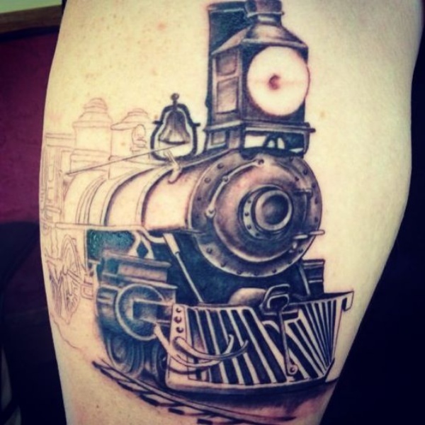 Unfinished half colored biceps tattoo of train near station