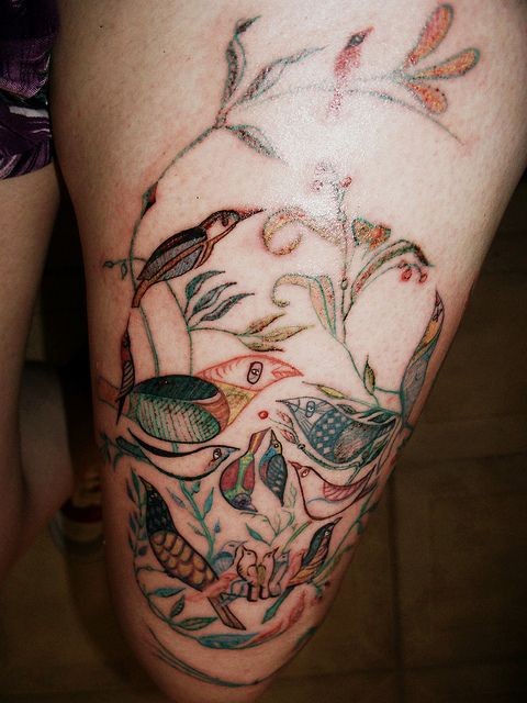 Tatuaje en la pierna, diseño surrealista, cráneo, aves en ramitas