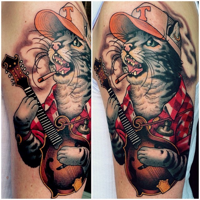 Illustrative style colored shoulder tattoo of cat rocker
