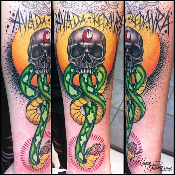 Illustrative style colored forearm tattoo of big snake with human skull and lettering