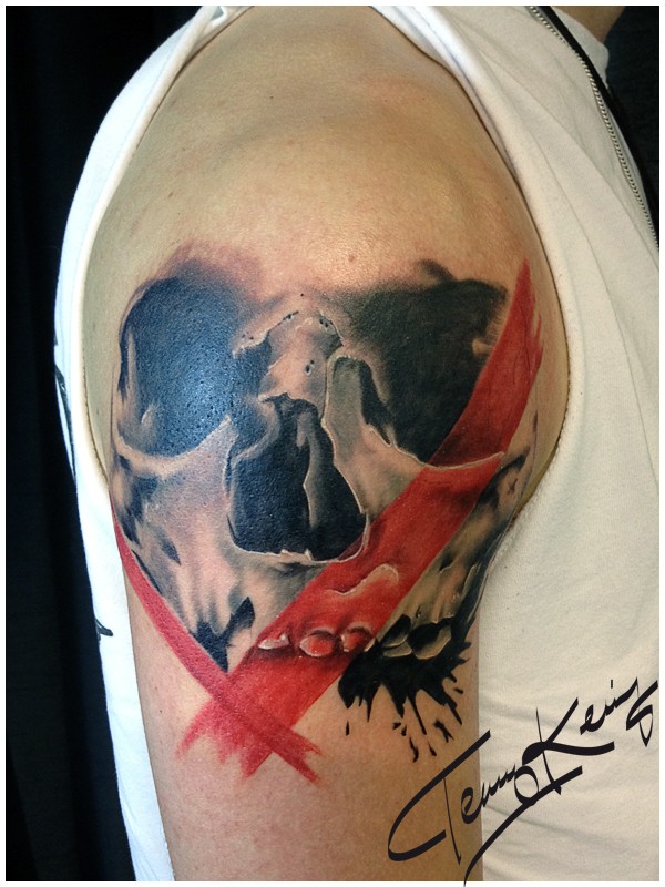 Illustrative style colored shoulder tattoo of human skull with red lines