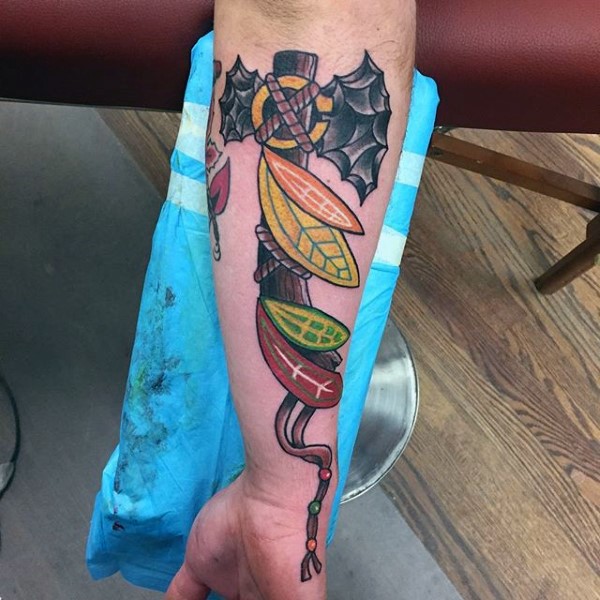 New school style colored arm tattoo of Indian axe with feather