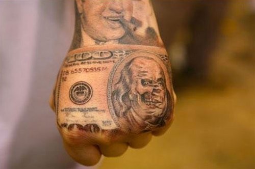 Unusual black and white dollar bill tattoo on hand