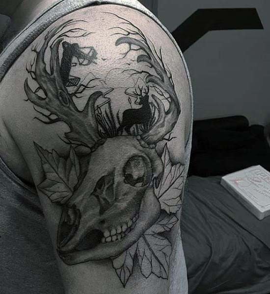 Unusual black ink animal skull with leaves tattoo on upper arm