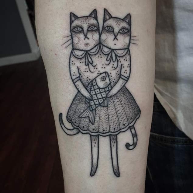 Unusual black ink cat with two heads and fish tattoo on forearm