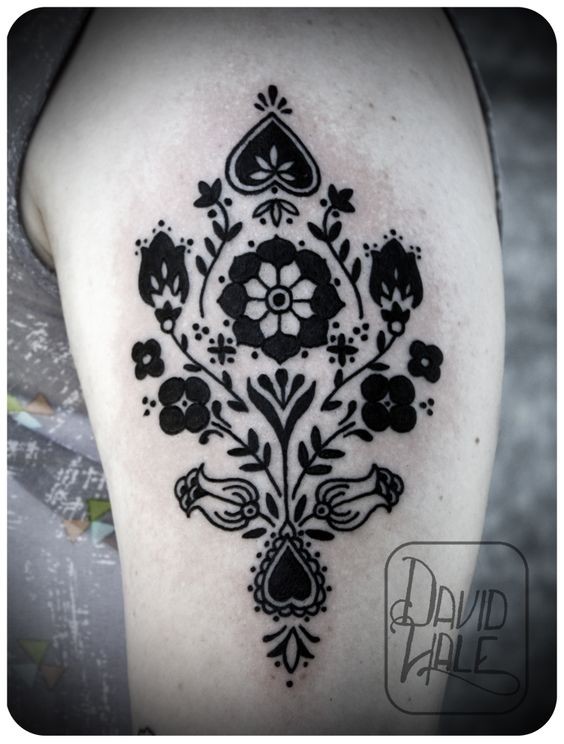 Unusual black ink shoulder tattoo of ornamental flowers