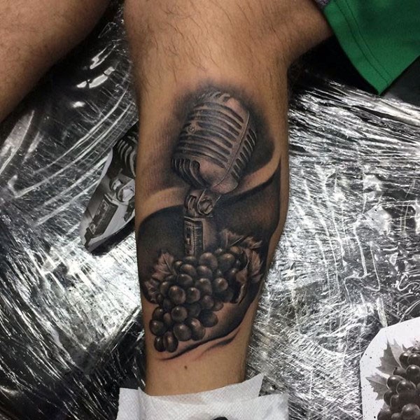 Tatuaje en la pierna, micrófono 3D con uva, colores oscuros