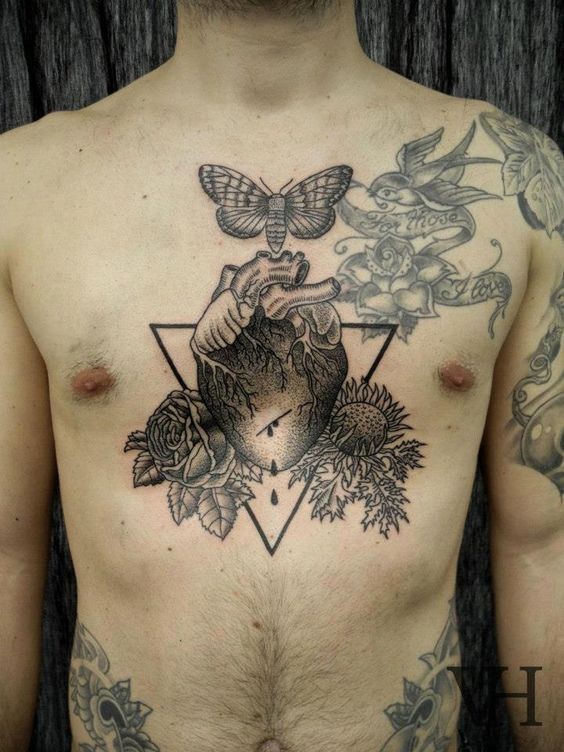 Unusual combined colored human heart tattoo on chest with flowers and night butterfly